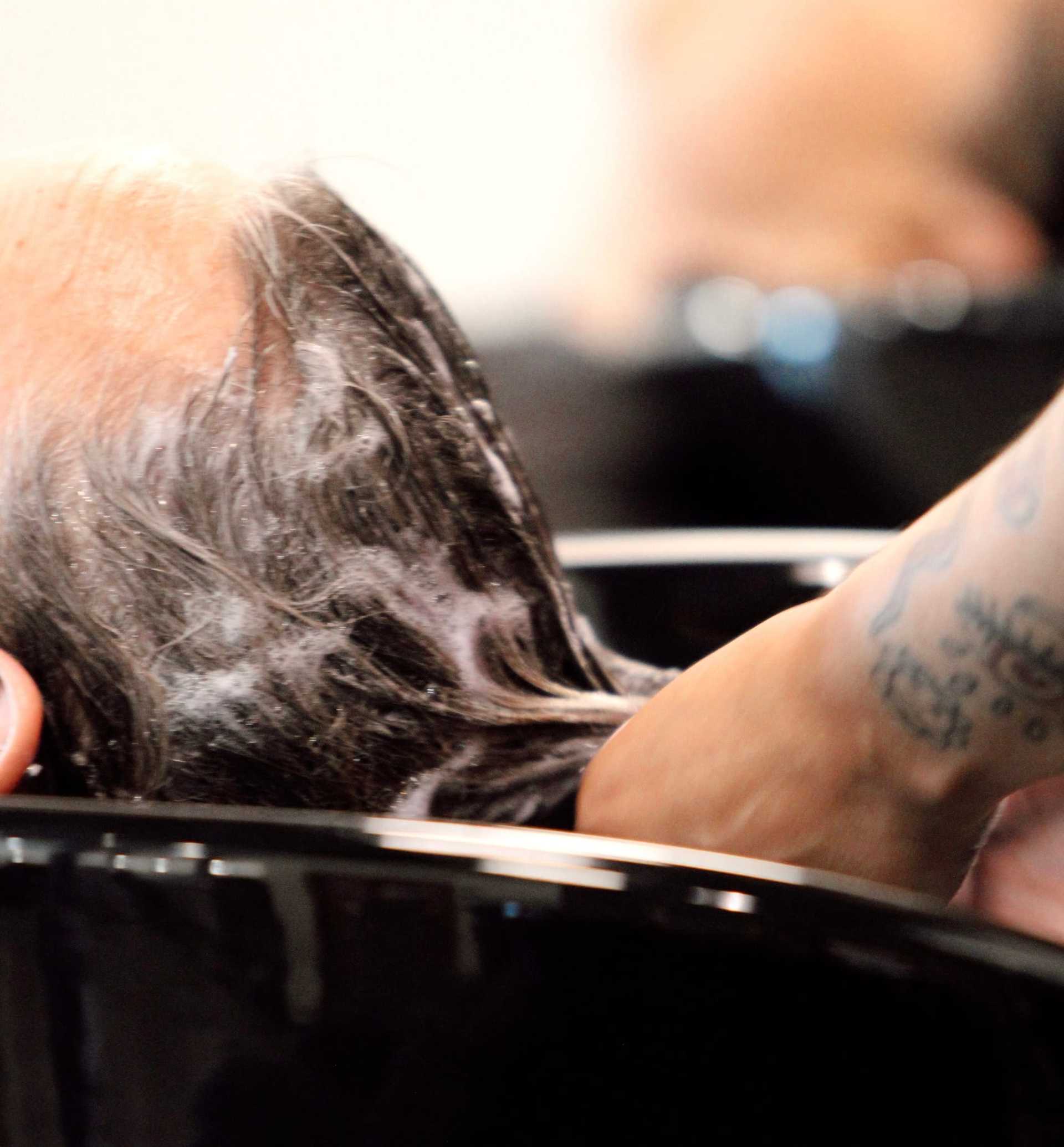 Person getting hair washed at a salon sink.